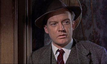 Movie still from “Elmer Gantry” (1960), directed by Richard Brooks – A person wearing a suit and a hat; Close Up shot, Over the shoulder angle