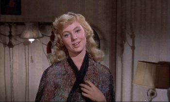 Movie still from “Elmer Gantry” (1960), directed by Richard Brooks – A woman with blonde hair is posing for a picture; Close Up shot, Over the shoulder angle