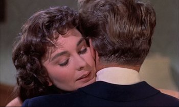Movie still from “Elmer Gantry” (1960), directed by Richard Brooks – A woman is hugging a man in a suit and tie; Close Up shot, Over the shoulder angle