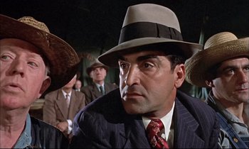 Movie still from “Elmer Gantry” (1960), directed by Richard Brooks – A man in a suit wearing a hat; Close Up shot, Low angle