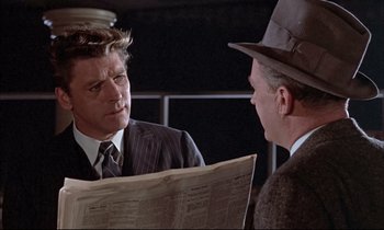 Movie still from “Elmer Gantry” (1960), directed by Richard Brooks – A man in a suit and a man in a hat are looking at a newspaper; Close Up shot, Over the shoulder angle