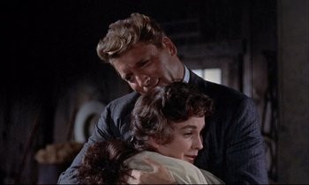 Movie still from “Elmer Gantry” (1960), directed by Richard Brooks – A man and a woman hugging each other while another woman looks on; Medium shot, Low angle