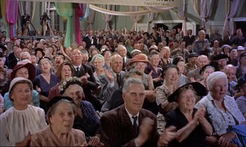 Movie still from “Elmer Gantry” (1960), directed by Richard Brooks – An old crowd of people clapping in front of an audience; Wide shot, High angle
