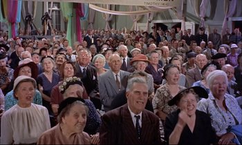 Movie still from “Elmer Gantry” (1960), directed by Richard Brooks – A large group of older people sitting in a crowd; Wide shot, High angle
