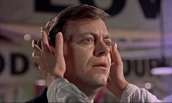 Movie still from “Elmer Gantry” (1960), directed by Richard Brooks – A person with their hands on their head; Close Up shot, Low angle