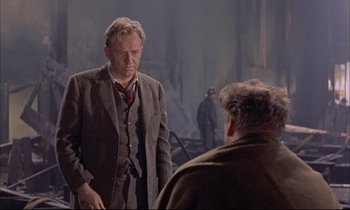 Movie still from “Elmer Gantry” (1960), directed by Richard Brooks – A man standing next to another man wearing a suit; Medium shot, Over the shoulder angle