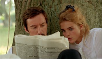 A man and a woman are reading a newspaper together