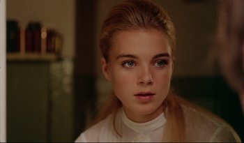 A young woman with blonde hair and blue eyes