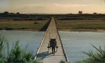 Movie still from “Empire of Passion” (1978), directed by Nagisa Ôshima – A man walking across a bridge with a horse drawn cart; Extreme Wide shot, High angle