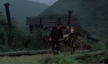Movie still from “Empire of Passion” (1978), directed by Nagisa Ôshima – A man and a woman sitting on a cart in a field; Extreme Wide shot, High angle