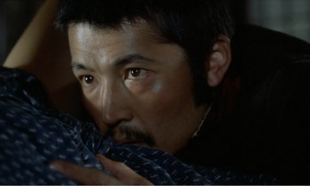 Movie still from “Empire of Passion” (1978), directed by Nagisa Ôshima – A person holding a pillow; Close Up shot, Over the shoulder angle