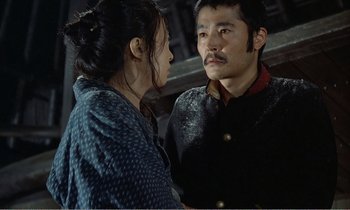 Movie still from “Empire of Passion” (1978), directed by Nagisa Ôshima – A man and a woman standing next to each other; Medium shot, Over the shoulder angle