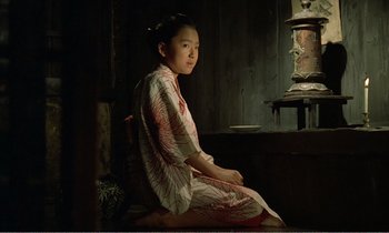 Movie still from “Empire of Passion” (1978), directed by Nagisa Ôshima – A woman in a kimono sitting on the ground; Medium shot, High angle