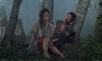 Movie still from “Empire of Passion” (1978), directed by Nagisa Ôshima – A man and a woman sitting in the woods; Medium shot, High angle