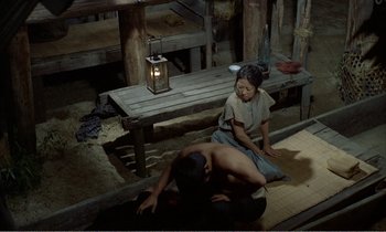 Movie still from “Empire of Passion” (1978), directed by Nagisa Ôshima – A woman sitting on the ground next to a man; Wide shot, High angle