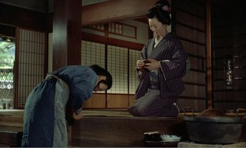 Movie still from “Empire of Passion” (1978), directed by Nagisa Ôshima – Two women in traditional japanese garb looking at a cell phone; Wide shot, Low angle