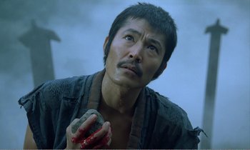 Movie still from “Empire of Passion” (1978), directed by Nagisa Ôshima – A man holding a rock with blood on his face; Close Up shot, High angle