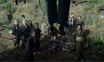 Movie still from “Empire of Passion” (1978), directed by Nagisa Ôshima – A group of people standing around a tree; Wide shot, Low angle