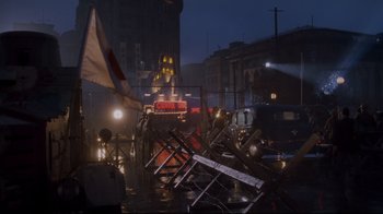 Movie still from “Empire of the Sun” (1987), directed by Steven Spielberg – A city street with a lot of street lights on it; Extreme Wide shot, Low angle