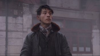 Movie still from “Empire of the Sun” (1987), directed by Steven Spielberg – A man in a brown jacket standing in the fog; Close Up shot, Low angle