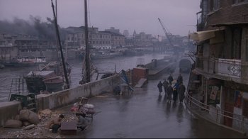 Movie still from “Empire of the Sun” (1987), directed by Steven Spielberg – A group of people standing next to a body of water; Extreme Wide shot, High angle