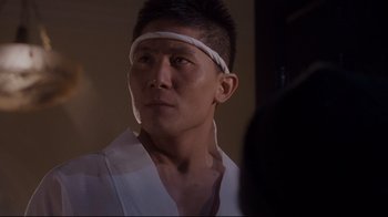 Movie still from “Empire of the Sun” (1987), directed by Steven Spielberg – A man wearing a headband looking into a mirror; Close Up shot, Low angle