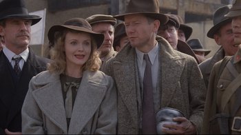 Movie still from “Empire of the Sun” (1987), directed by Steven Spielberg – A man and a woman in a crowd of people; Medium shot, Over the shoulder angle