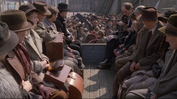 Movie still from “Empire of the Sun” (1987), directed by Steven Spielberg – A group of people sitting on top of a wooden boat; Wide shot, High angle