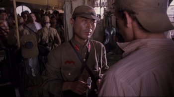 Movie still from “Empire of the Sun” (1987), directed by Steven Spielberg – A man in a military uniform is talking to another man; Close Up shot, Over the shoulder angle