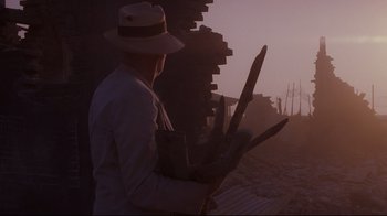 Movie still from “Empire of the Sun” (1987), directed by Steven Spielberg – A man in a white hat holding a bunch of wood; Wide shot, Low angle