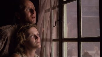 Movie still from “Empire of the Sun” (1987), directed by Steven Spielberg – A man and a woman looking out of a window; Close Up shot, Low angle