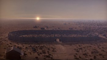 Movie still from “Empire of the Sun” (1987), directed by Steven Spielberg – An aerial view of a desert with a sunset in the background; Extreme Wide shot, High angle