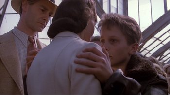 Movie still from “Empire of the Sun” (1987), directed by Steven Spielberg – A group of people that are standing up together; Close Up shot, Over the shoulder angle