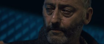 Movie still from “Empire of the Wolves” (2005), directed by Chris Nahon – A man with a beard and mustache; Close Up shot, Over the shoulder angle