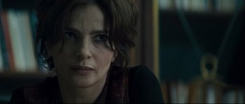 Movie still from “Empire of the Wolves” (2005), directed by Chris Nahon – A person with short brown hair; Close Up shot, Over the shoulder angle