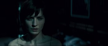 Movie still from “Empire of the Wolves” (2005), directed by Chris Nahon – A woman with short dark hair stares into the camera; Close Up shot, Over the shoulder angle