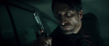 Movie still from “Empire of the Wolves” (2005), directed by Chris Nahon – A person holding a gun; Close Up shot, Low angle
