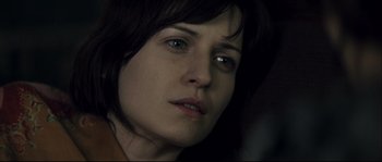 Movie still from “Empire of the Wolves” (2005), directed by Chris Nahon – A woman's face in a dimly - lit room; Close Up shot, Over the shoulder angle