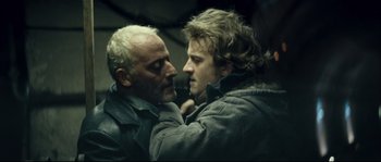 Movie still from “Empire of the Wolves” (2005), directed by Chris Nahon – Two men are touching each other's faces; Close Up shot, Low angle