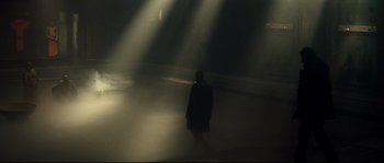 Movie still from “Empire of the Wolves” (2005), directed by Chris Nahon – A person standing in a room with lights shining on them; Extreme Wide shot, Low angle