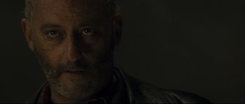 Movie still from “Empire of the Wolves” (2005), directed by Chris Nahon – A person's face in a dark room; Close Up shot, Low angle