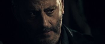Movie still from “Empire of the Wolves” (2005), directed by Chris Nahon – A man's face in the dark; Close Up shot, Over the shoulder angle