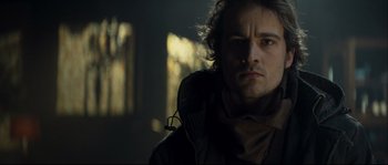 Movie still from “Empire of the Wolves” (2005), directed by Chris Nahon – A person wearing a hooded jacket; Close Up shot, Low angle