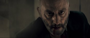 Movie still from “Empire of the Wolves” (2005), directed by Chris Nahon – A person with a knife in his mouth; Close Up shot, Low angle