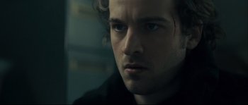Movie still from “Empire of the Wolves” (2005), directed by Chris Nahon – A man's face in a dark room; Close Up shot, Over the shoulder angle