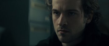 Movie still from “Empire of the Wolves” (2005), directed by Chris Nahon – A man's face in a dark room; Close Up shot, Over the shoulder angle