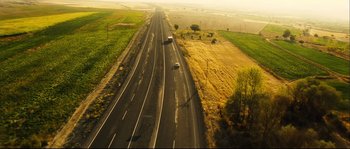 Movie still from “Empire of the Wolves” (2005), directed by Chris Nahon – An aerial view of a highway with cars driving on it; Extreme Wide shot, High angle