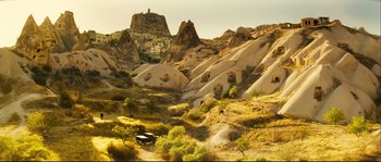 Movie still from “Empire of the Wolves” (2005), directed by Chris Nahon – A view of a mountain range with a church in the background; Extreme Wide shot, High angle