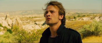 Movie still from “Empire of the Wolves” (2005), directed by Chris Nahon – A man with long brown hair looking to his left; Close Up shot, Low angle