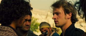 Movie still from “Empire of the Wolves” (2005), directed by Chris Nahon – A group of men standing next to each other on top of a hill; Close Up shot, Over the shoulder angle